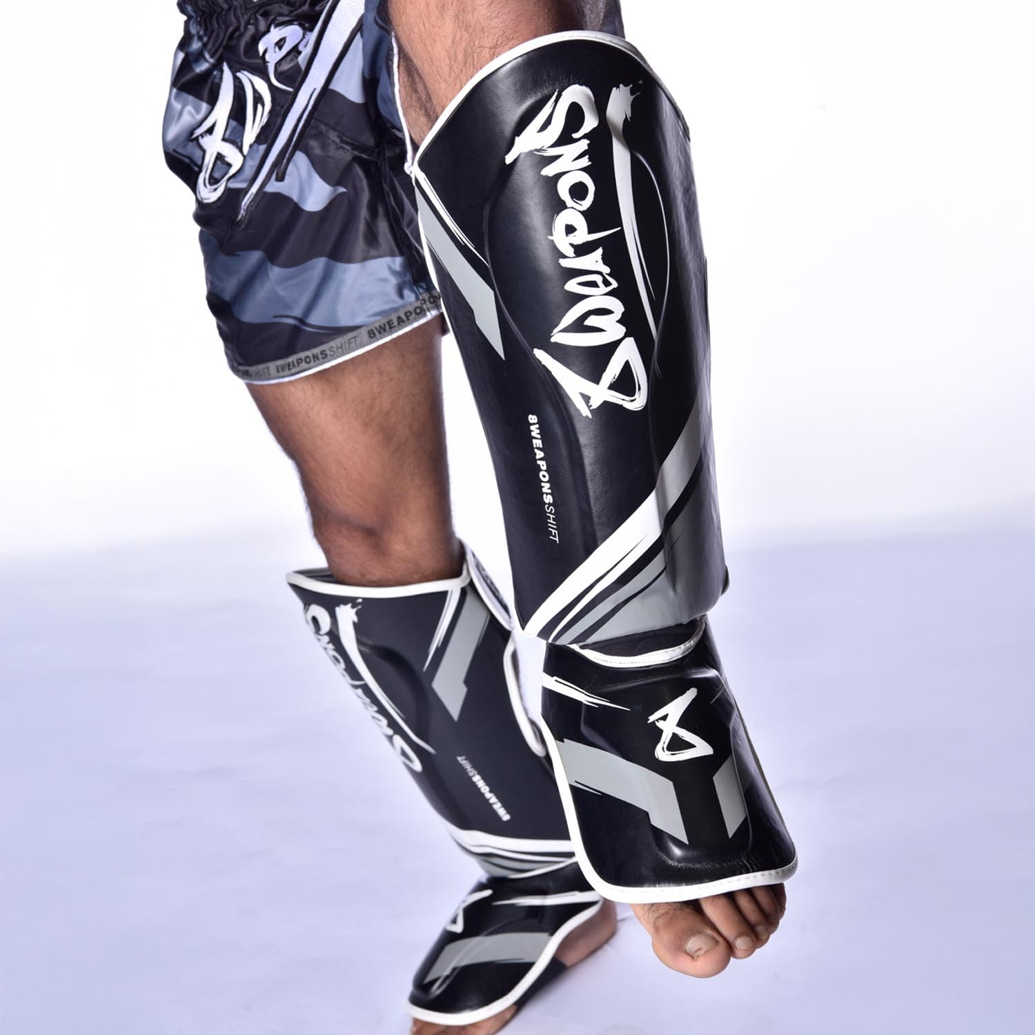 8 WEAPONS Espinilleras Shift, color blanco y negro, entrenamiento y competición, piel sintética de alta calidad y amortiguación perfecta, Muay Thai, K1, MMA, karate y kickboxing