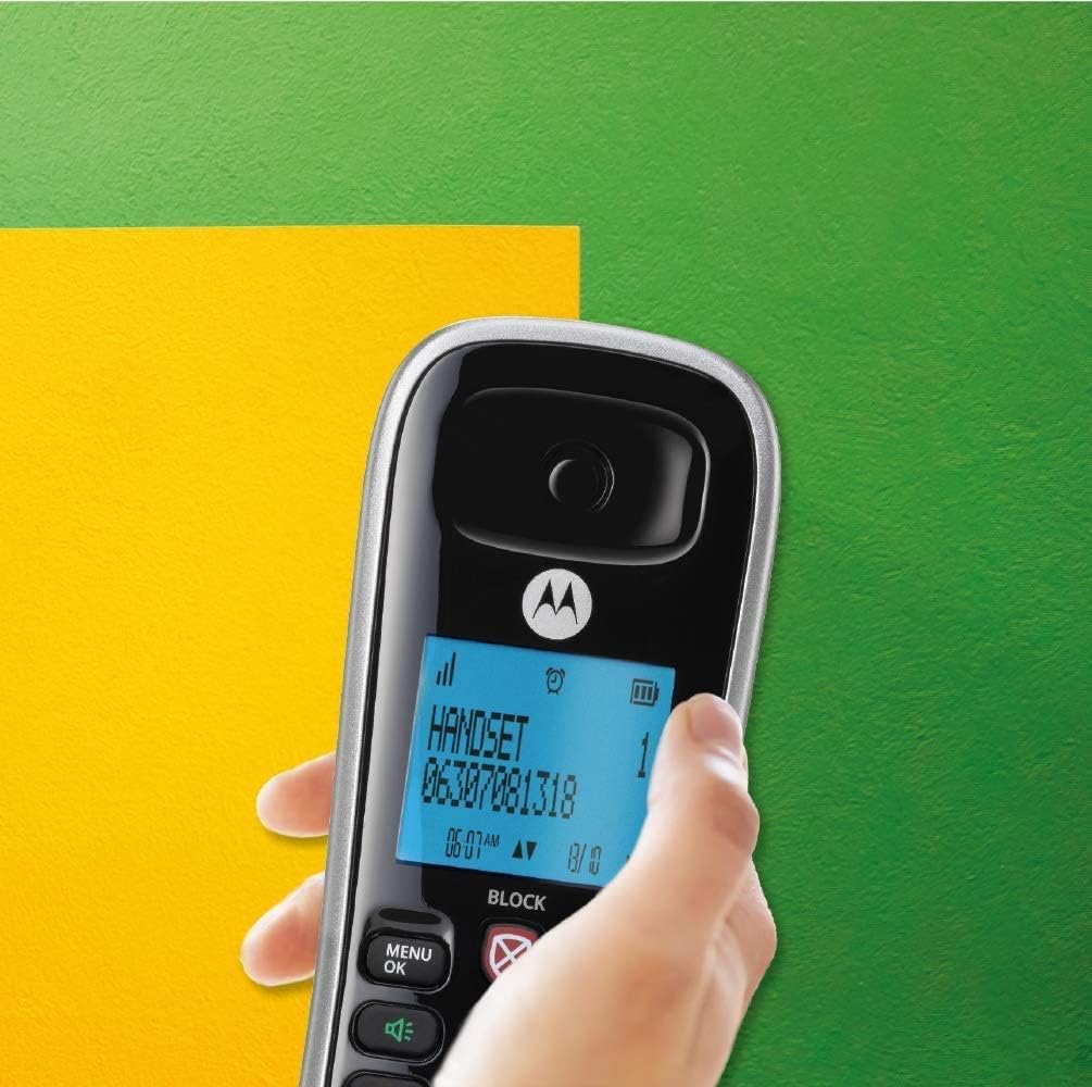 A hand holding a Motorola CD4013 cordless phone handset, showing the backlit screen and keypad.