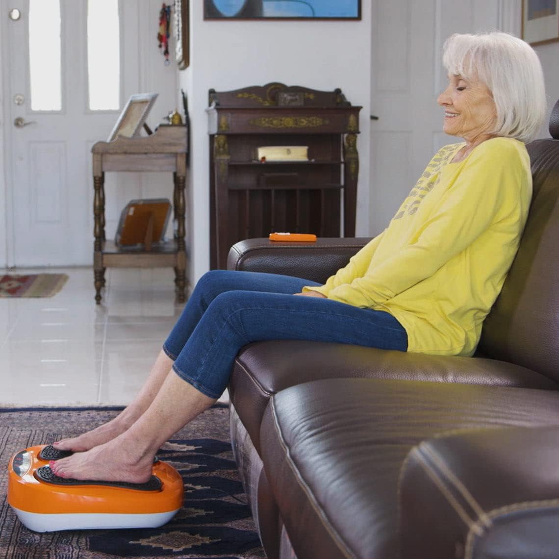 Woman relaxing on a couch with her feet on the VibroLegs device