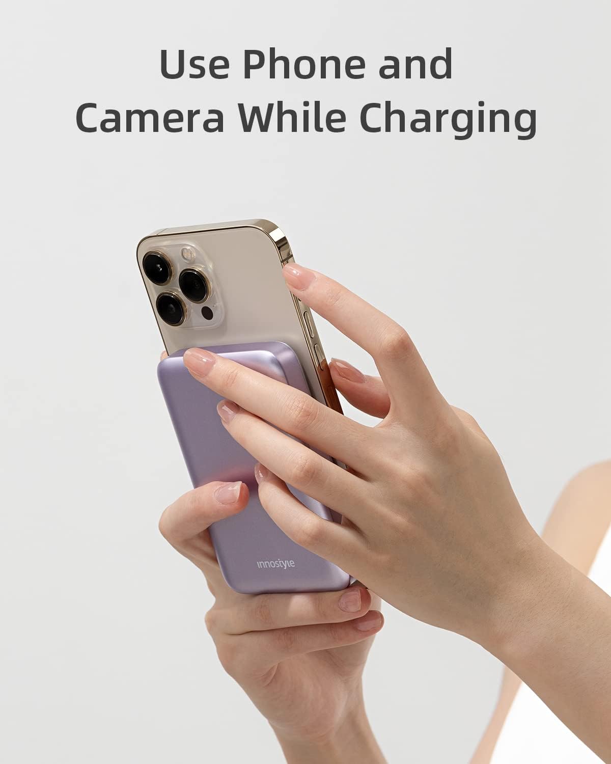 A hand holding an iPhone with the Innostyle Power Bank attached, demonstrating camera accessibility