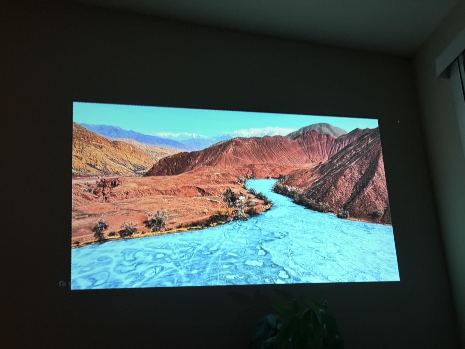 Projector showing river and mountain landscape on wall
