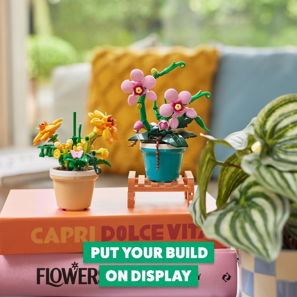Two different MAX Garden building brick plants displayed on a stack of books.