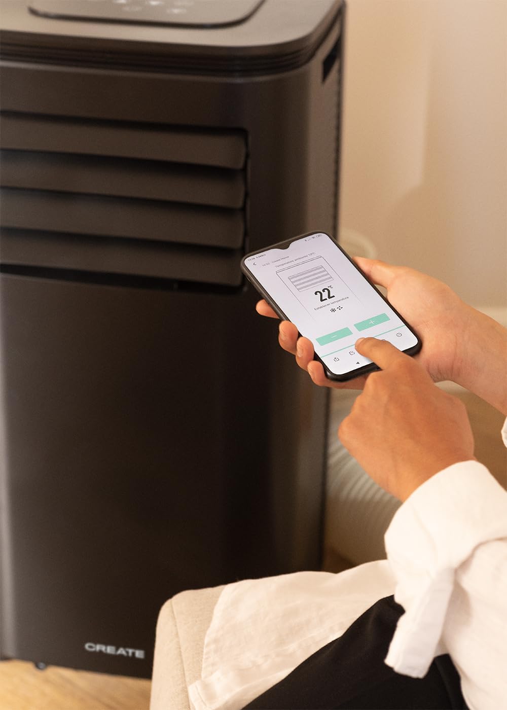 A hand pressing a button on the top control panel of the air conditioner.