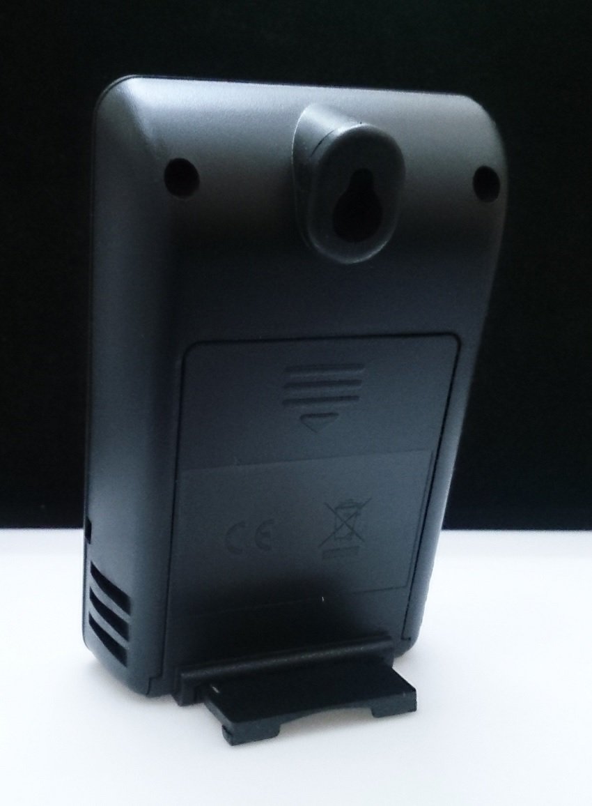 Rear view of the black wireless remote sensor, showing the battery compartment cover, a wall-mount hole, and a small foldable stand.