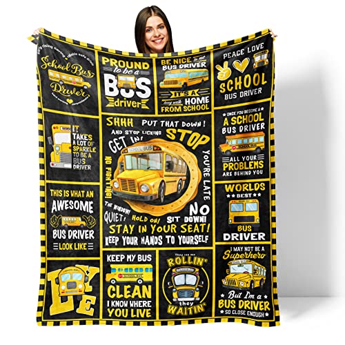 Woman holding up a black blanket with yellow font of school buses and funny bus sayings