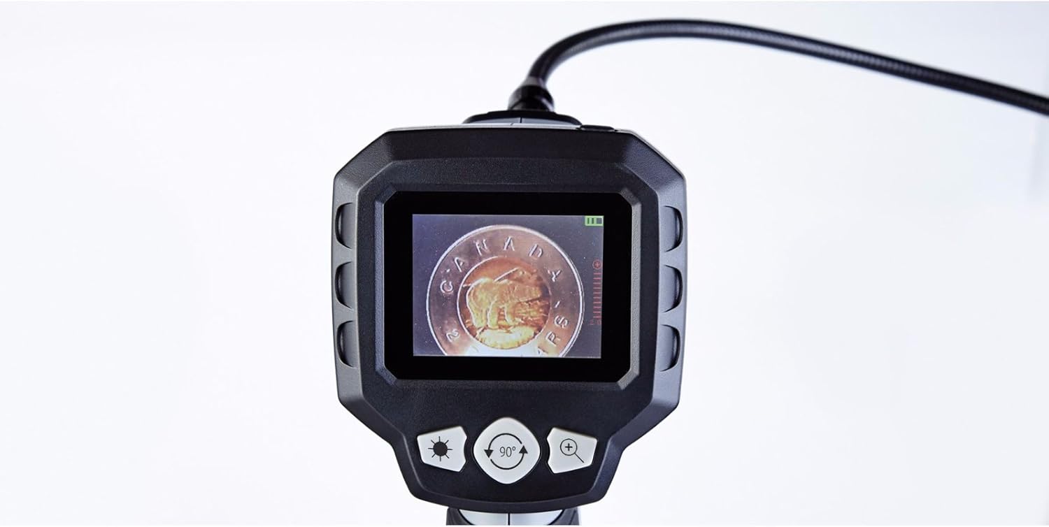 The main unit of the inspection camera showing a coin on its 2.7-inch LCD screen, with control buttons visible.