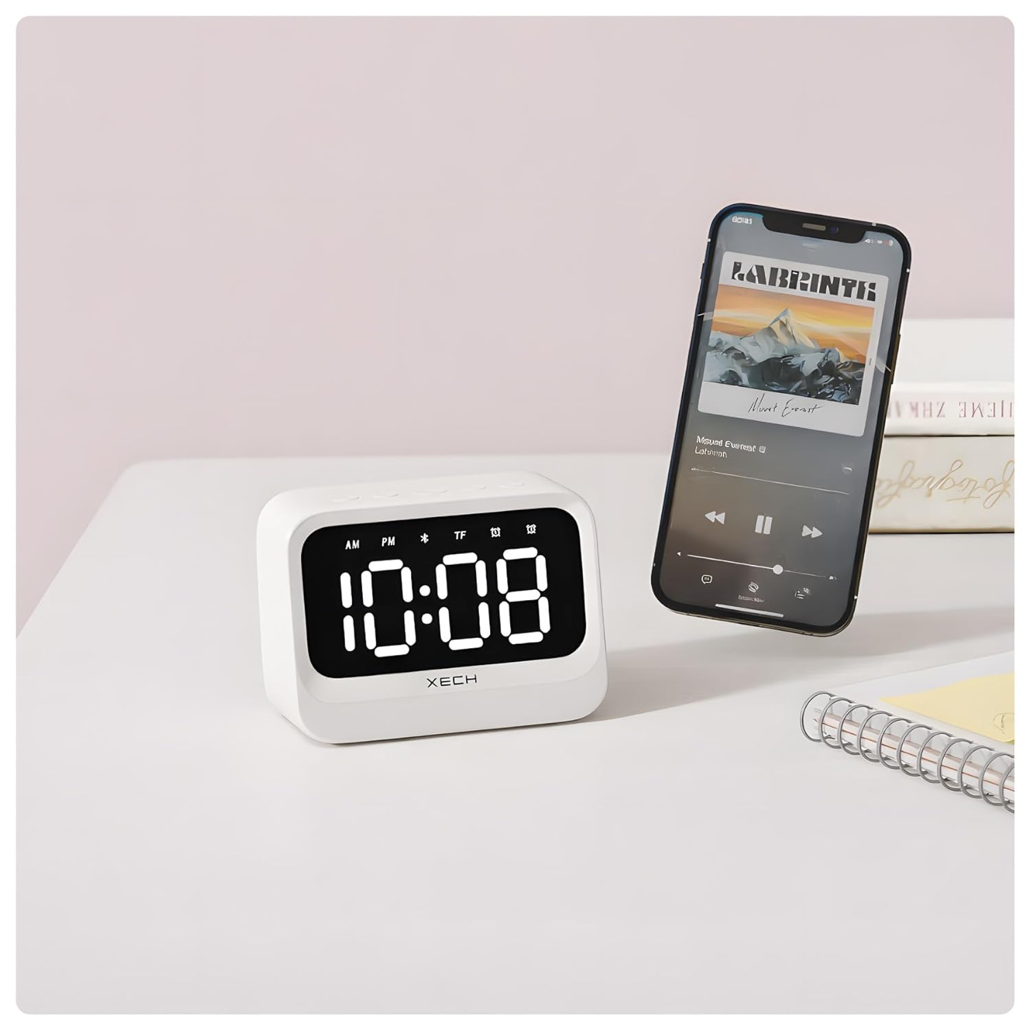 Xech X-609/A Mini Alarm Clock next to a smartphone playing music via Bluetooth.