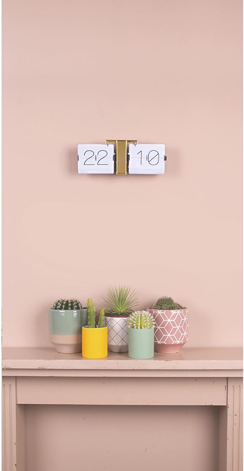 Karlsson Flip Clock displayed on a shelf with potted plants