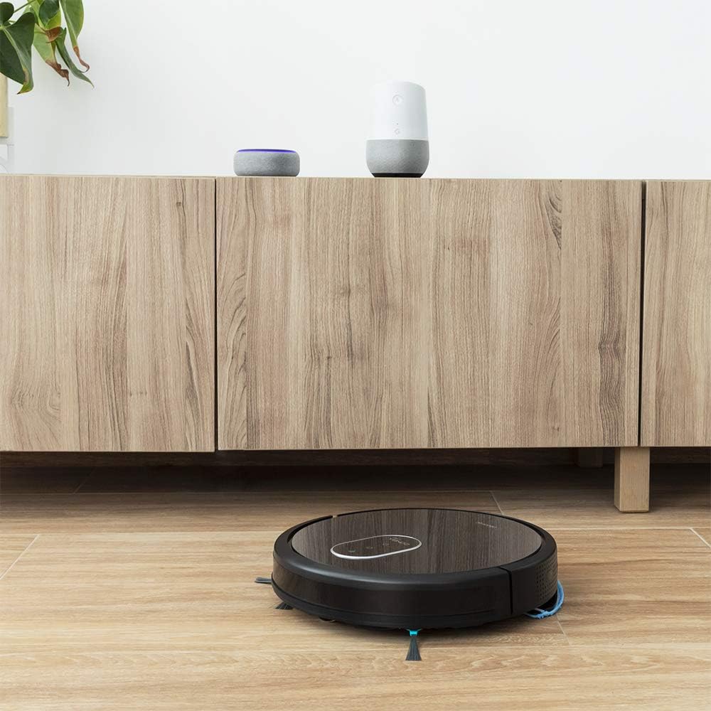Robot aspirapolvere Cecotec Conga 1790 Vital in un soggiorno con un Amazon Echo Dot e un Google Home Mini sullo sfondo, a indicare la compatibilità con il controllo vocale.