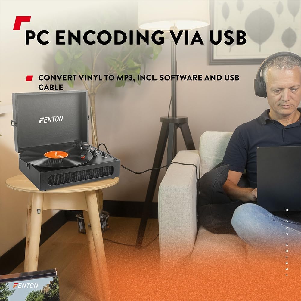A person wearing headphones, sitting at a laptop, with the Fenton RP118B turntable on a side table, demonstrating the USB encoding feature.