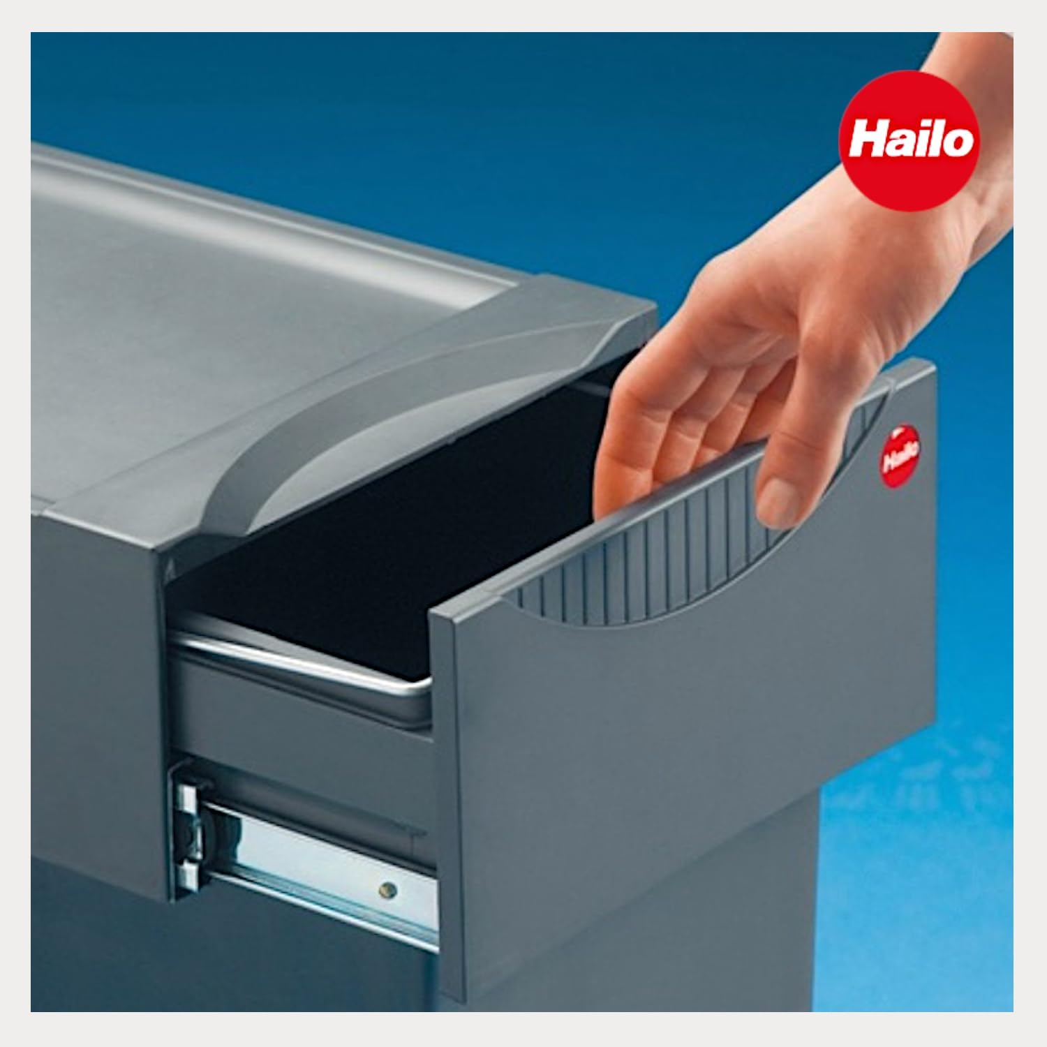 A hand pulling out the Hailo TA Swing 30.2/31 waste collector from a cabinet.