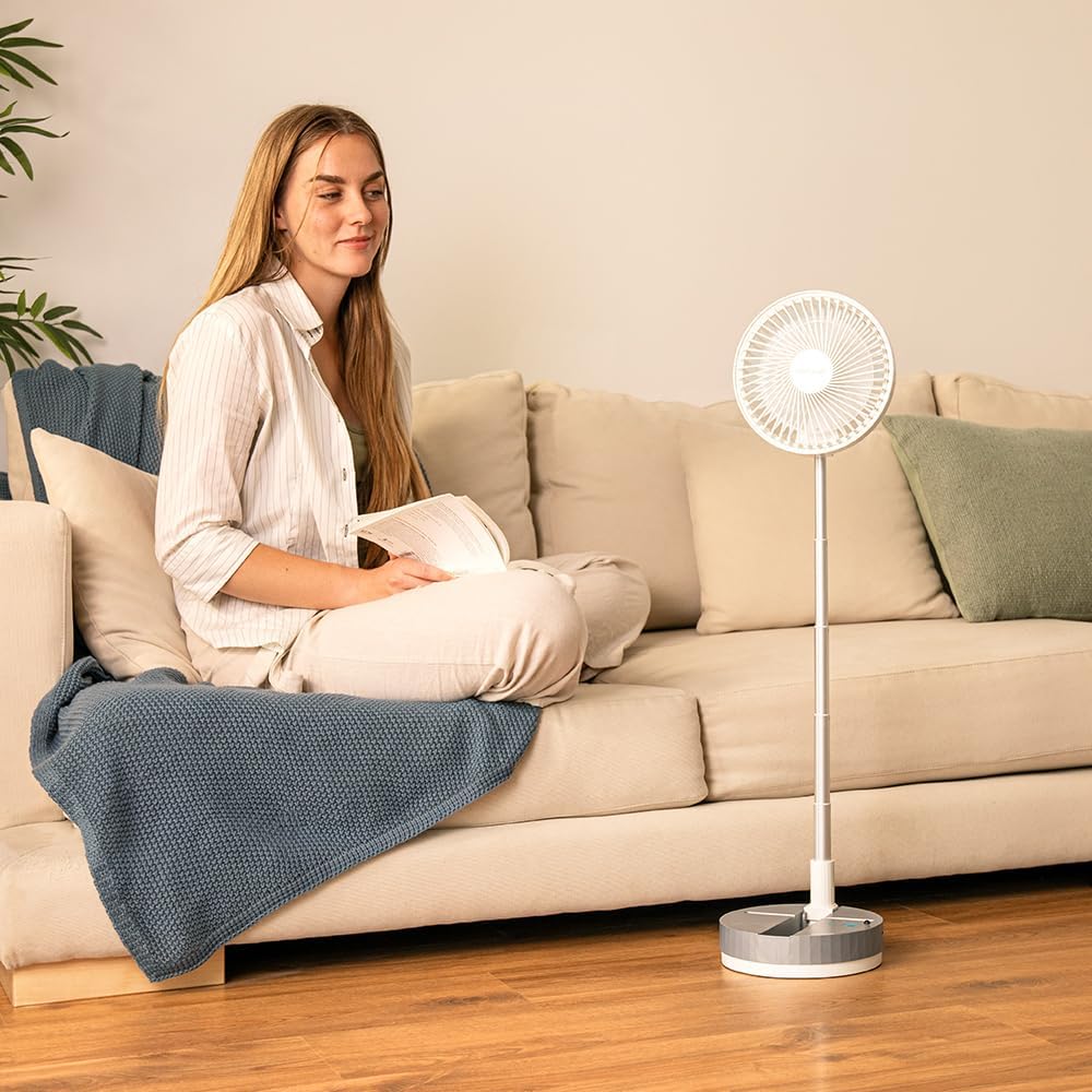 Finger pressing the power button on the fan's base.