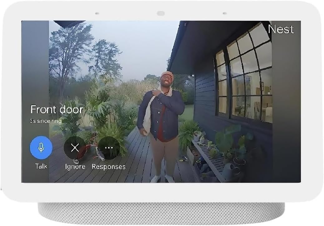 A hand pressing the button on a white Google Nest Doorbell mounted on a wall.