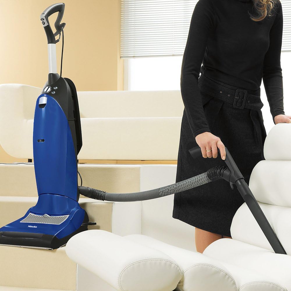 Person using the Miele S7210 Twist hose and crevice tool to clean upholstery