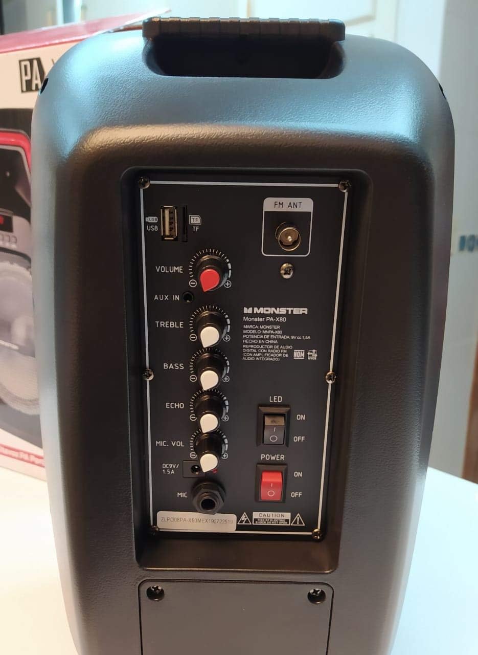 Dettagliato view del pannello di controllo posteriore dell'altoparlante Monster PA X80, che mostra gli ingressi per USB, AUX, microfono, volume, alti, bassi, eco e interruttori di accensione.