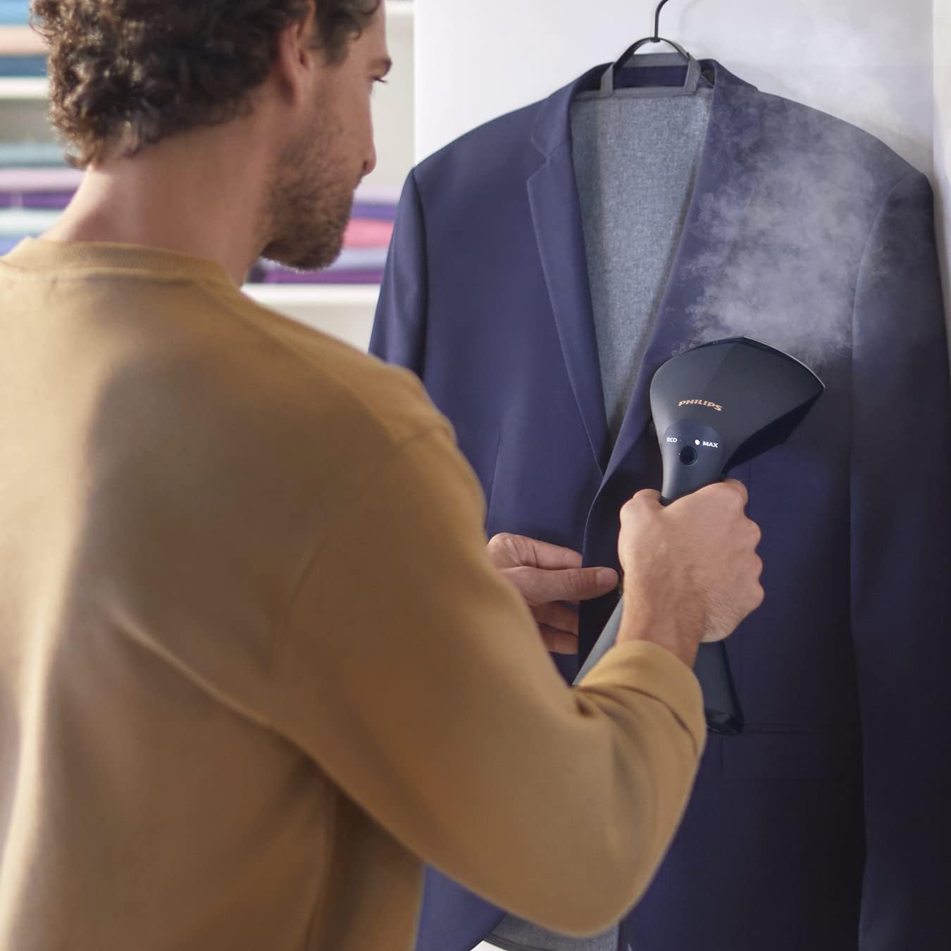 Man vertically steaming a jacket with Philips GC810/20