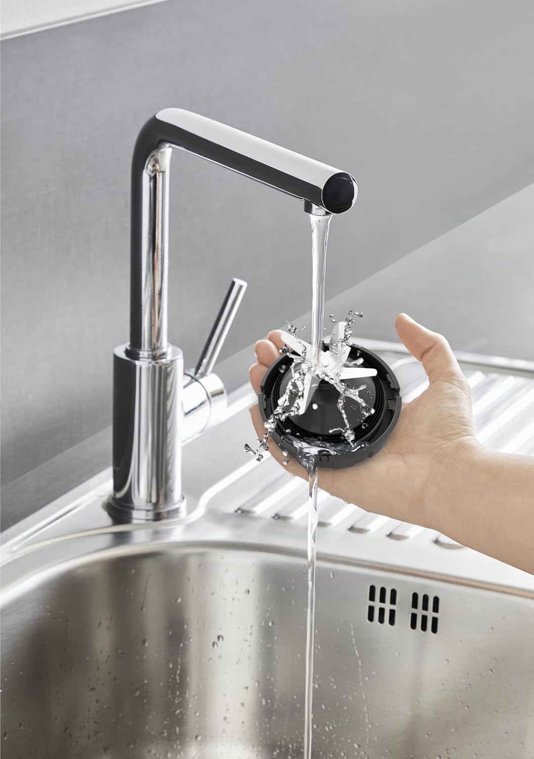 Hand washing a blender blade under running water