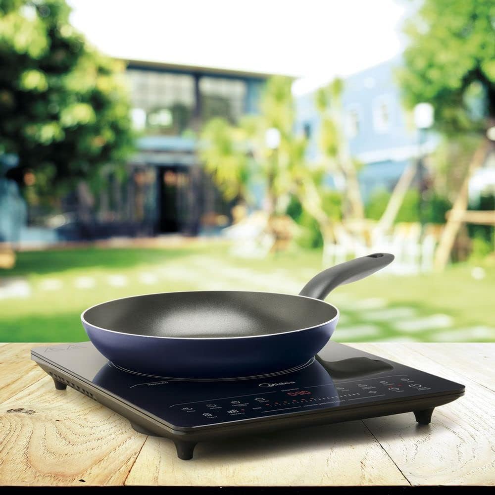 Midea Induction Cooktop with an empty pan on a wooden table outdoors