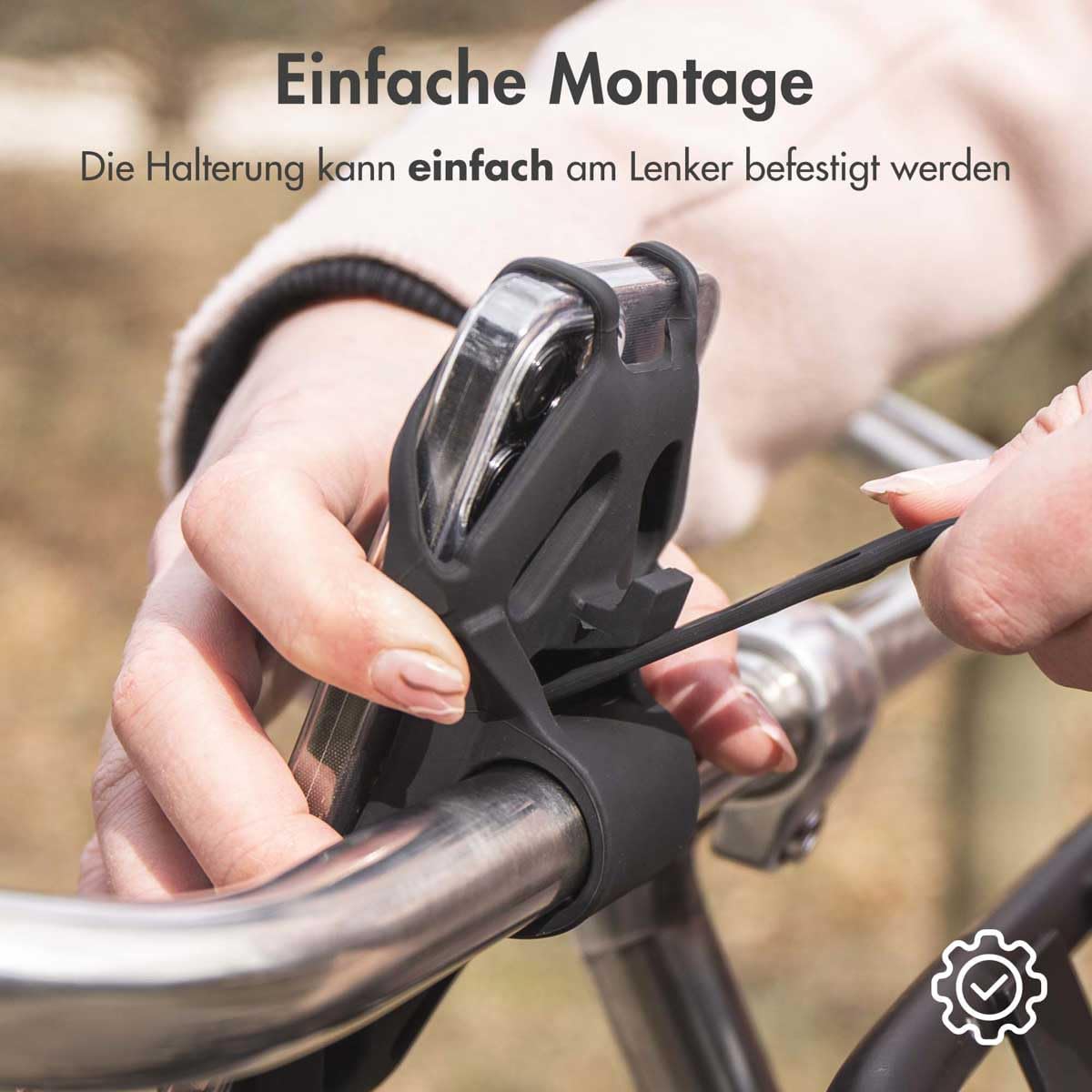 Hands demonstrating the easy attachment of the iMoshion bike mount to a bicycle handlebar
