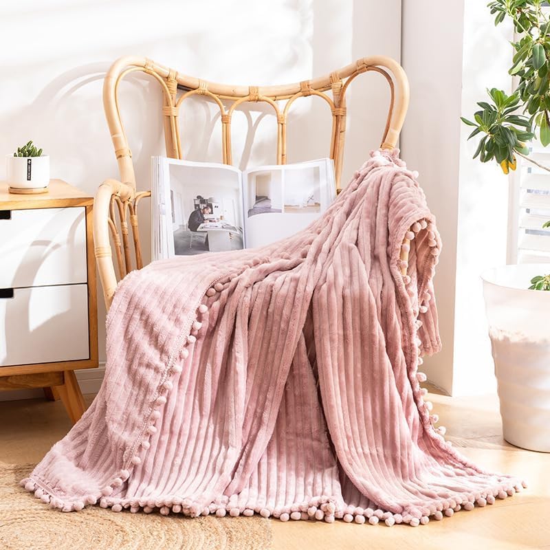 Couverture à franges en polaire contre le froid sur le canapé