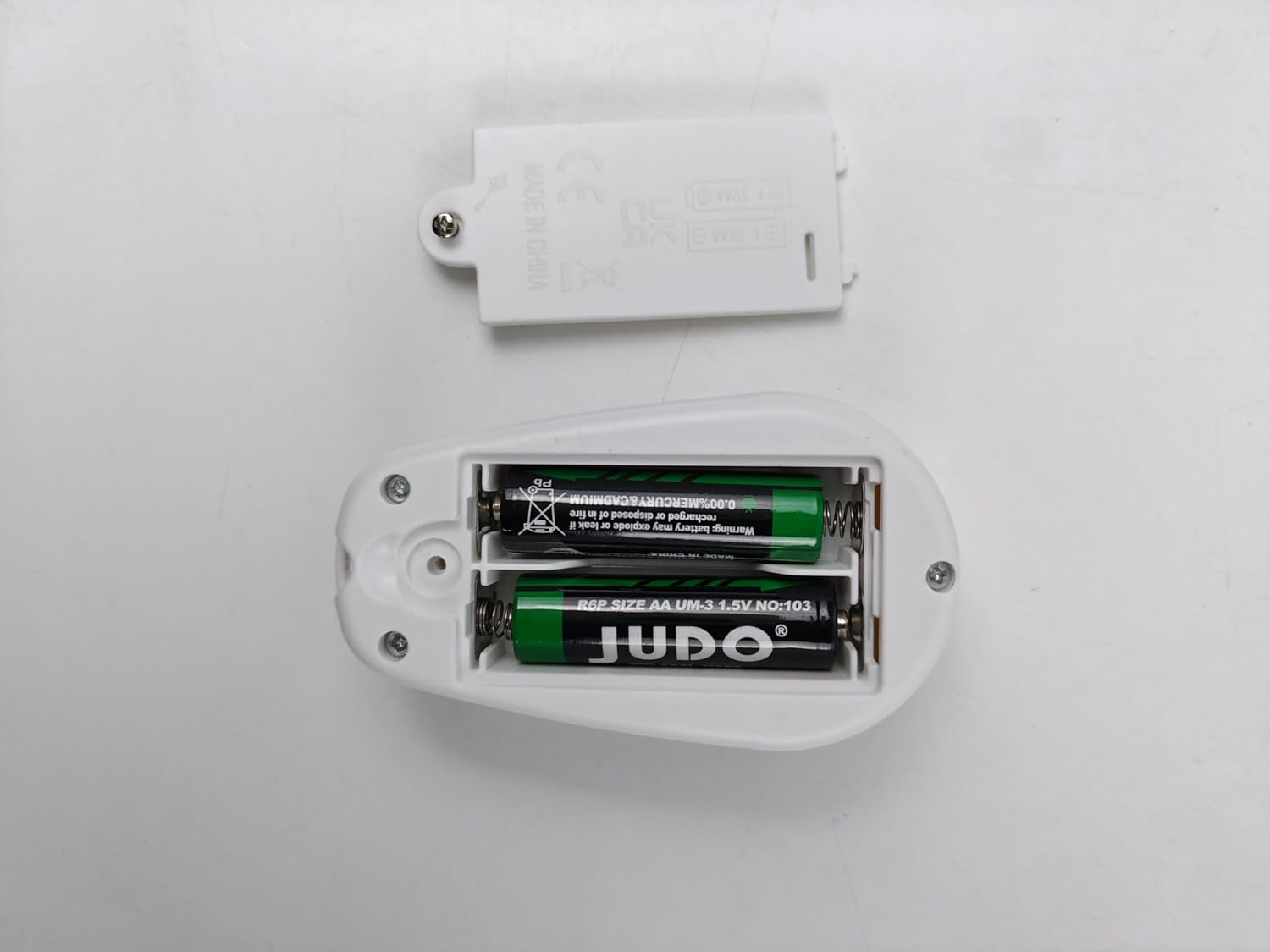 Image showing the open battery compartment of the remote control with two AA batteries inserted.