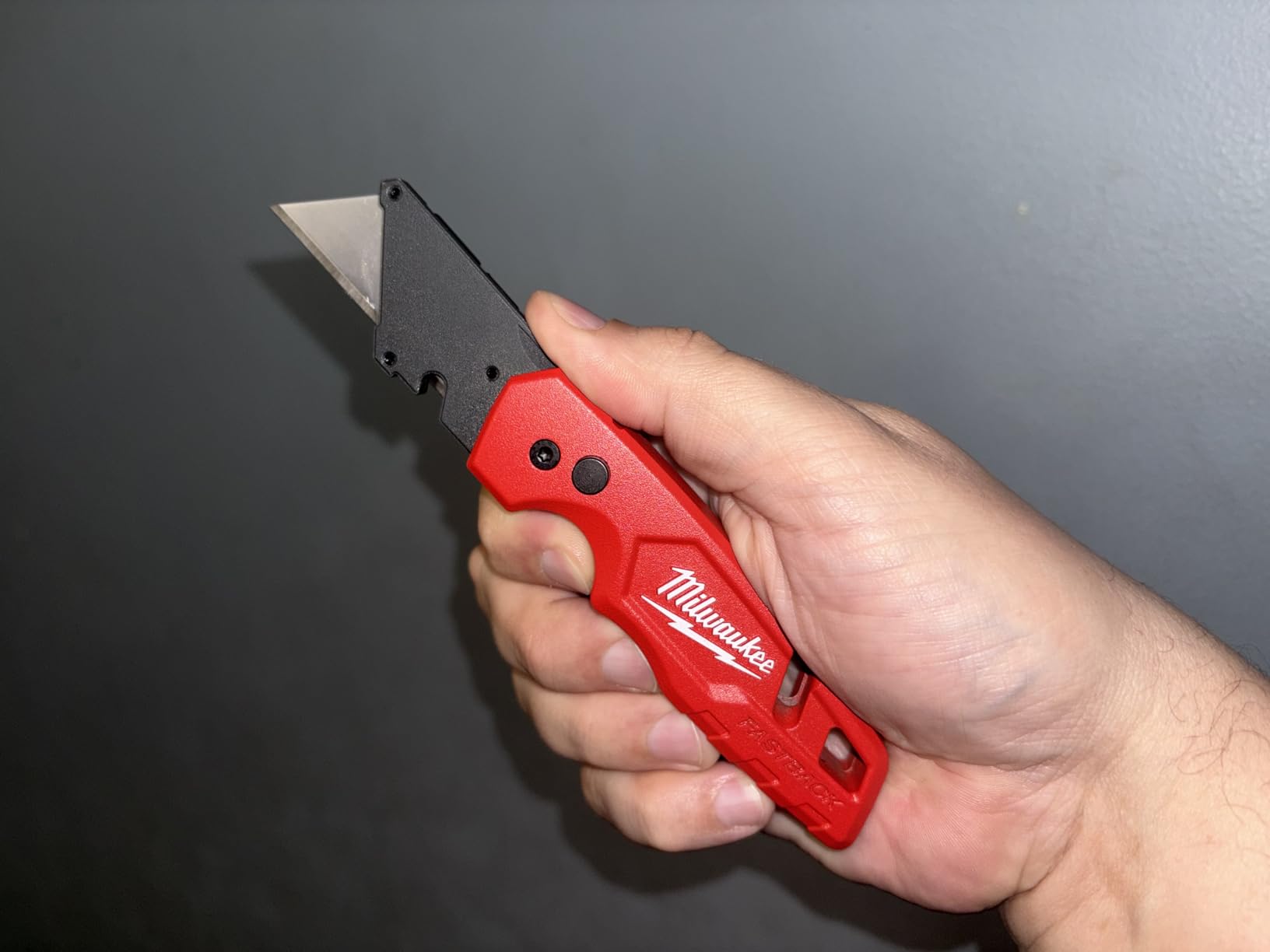 Milwaukee Fastback utility knives on a construction site background