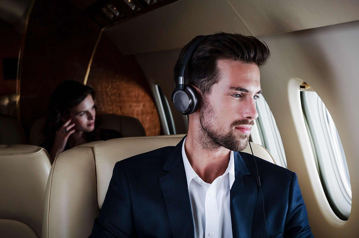 Man wearing Philips NC1 headphones on an airplane, looking out the window