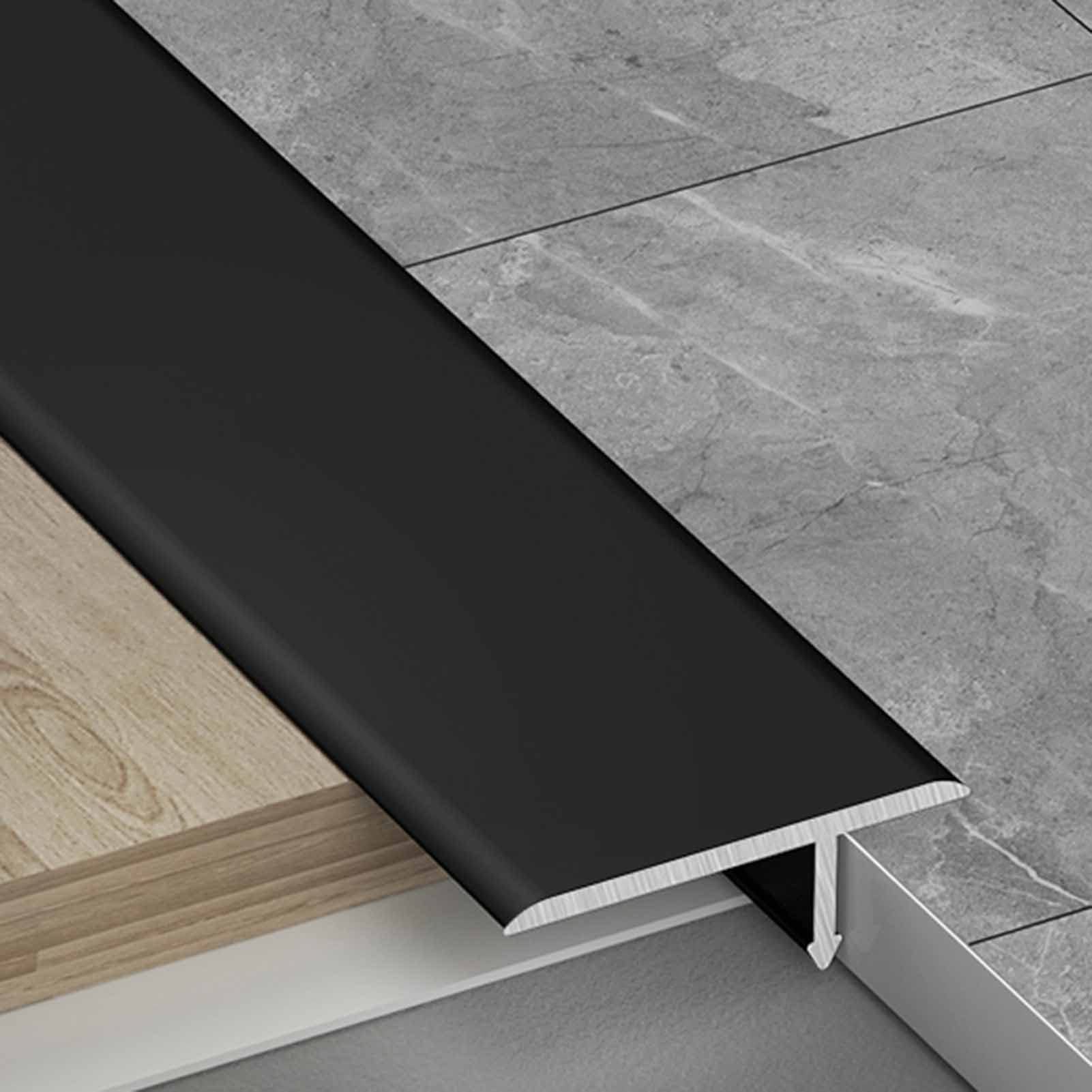 Tira de moldura en T negra para conectar suelos de cocina y salón moderno