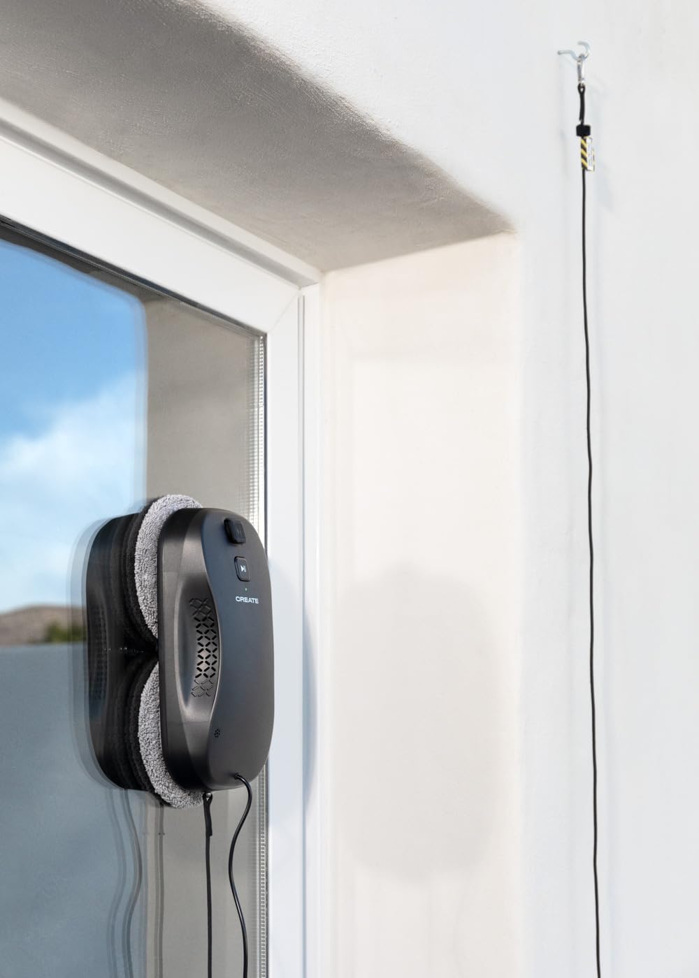 WIPEBOT Pro on window with safety rope attached to a hook