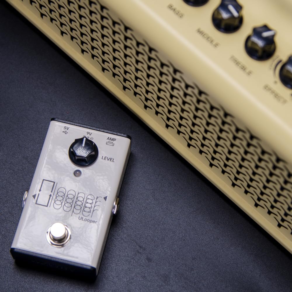 The XSONIC ULooper pedal positioned next to a guitar amplifier, illustrating a typical setup.