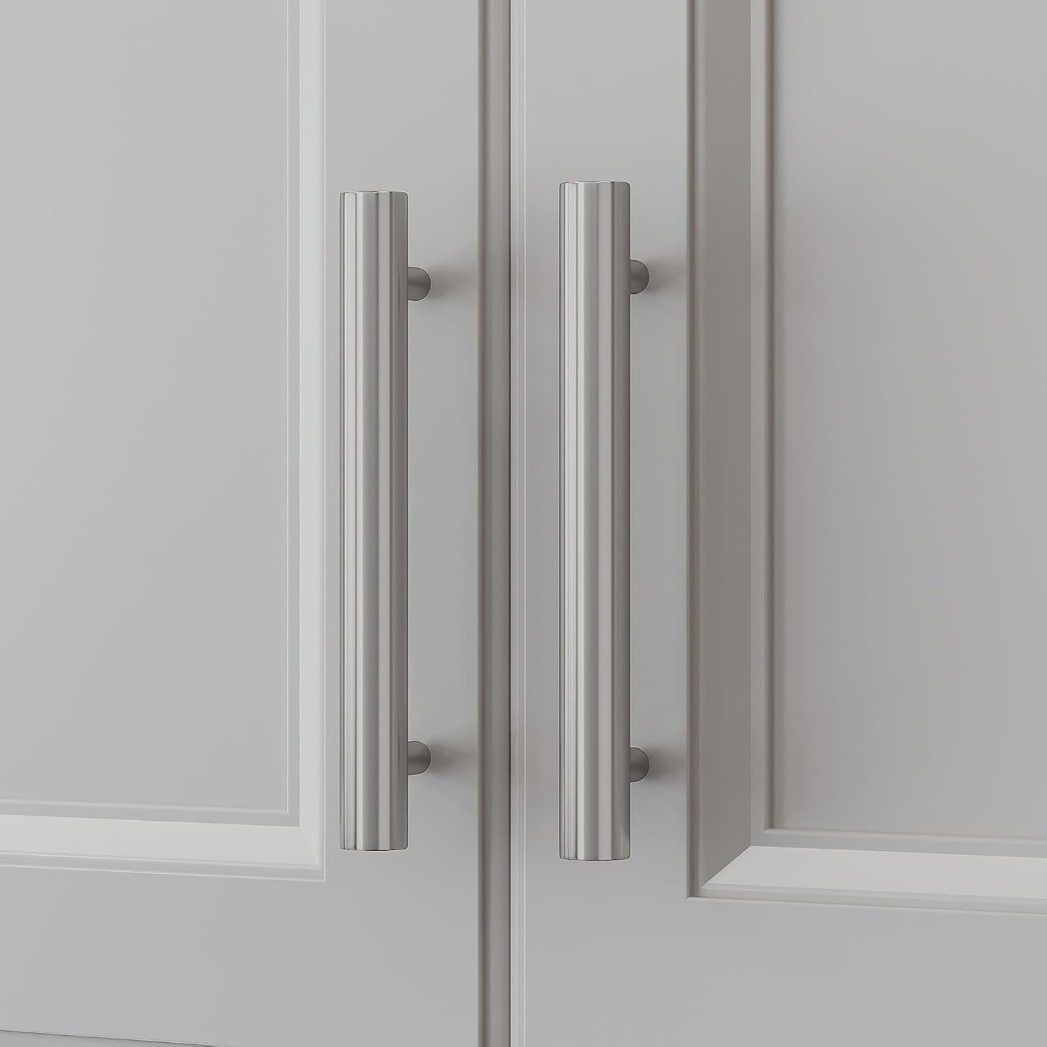 Two homdiy brushed nickel cabinet handles installed on light gray cabinet doors