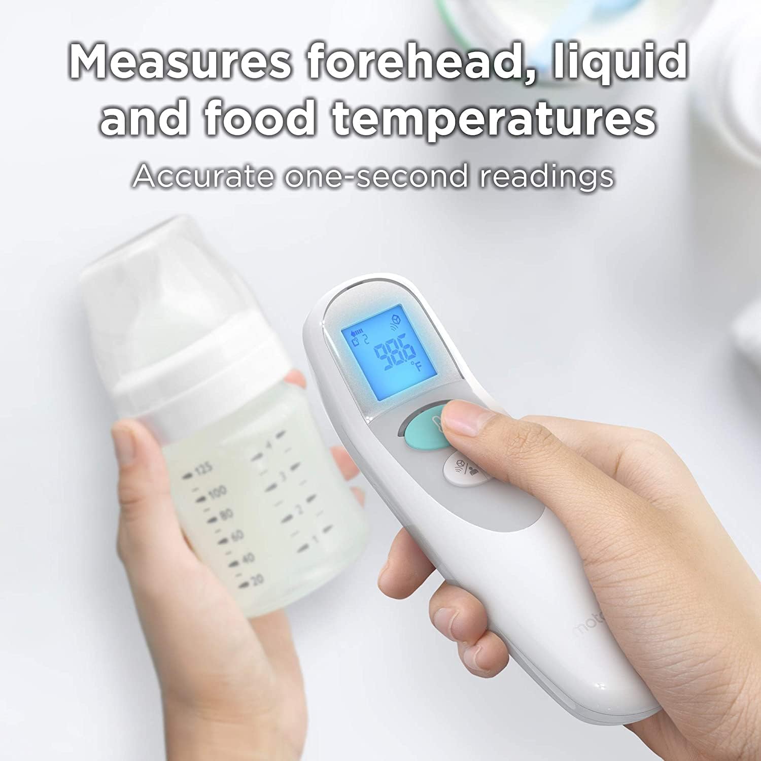 Hand holding the thermometer, pointing it at a baby bottle to measure liquid temperature