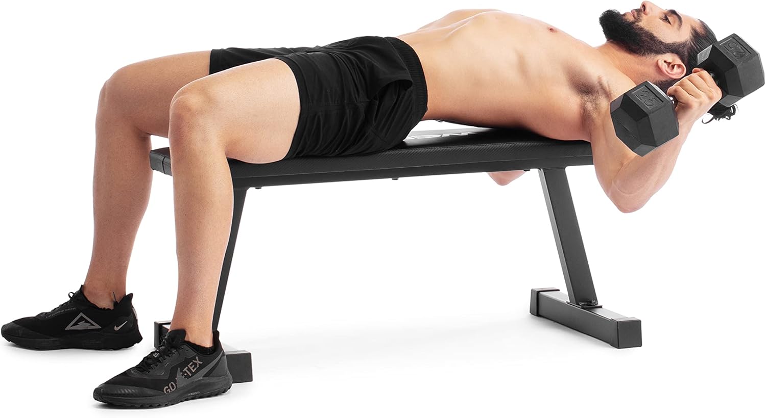 A man performing a dumbbell chest press while lying on the Weider Legacy Flat Bench.