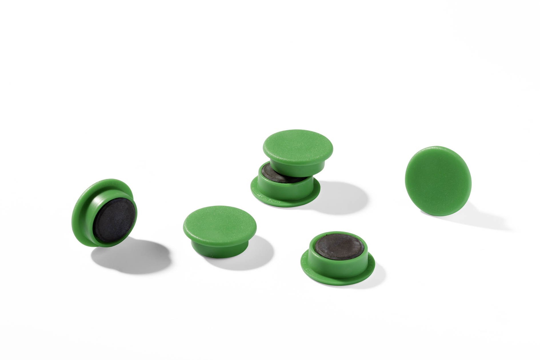 Several green round magnets with a black magnetic base, some showing the grip edge.