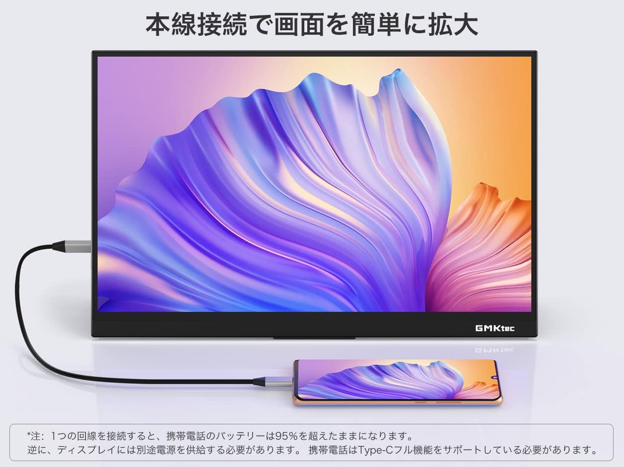 A smartphone connected to the GMKtec portable monitor, displaying the phone's screen on the larger monitor.