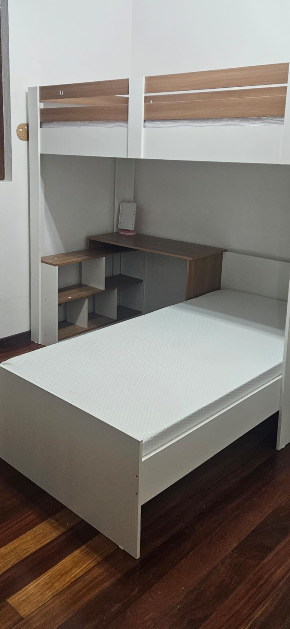 Colchão Emma Basics 17 posicionado sobre uma cama de solteiro de madeira e branca em um quarto