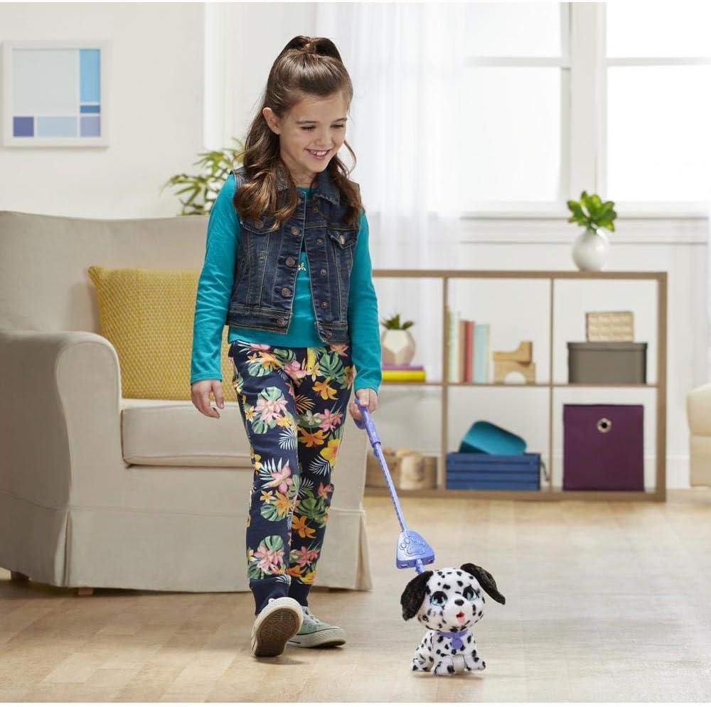 A child happily walking the FurReal Big Wags Dog with its leash across a wooden floor.