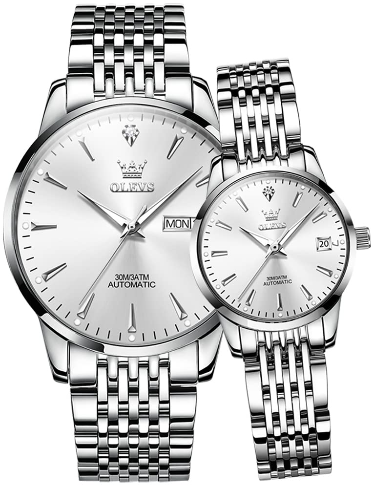 A pair of OLEVS automatic mechanical watches, silver-toned with white dials, displayed in a watch box.