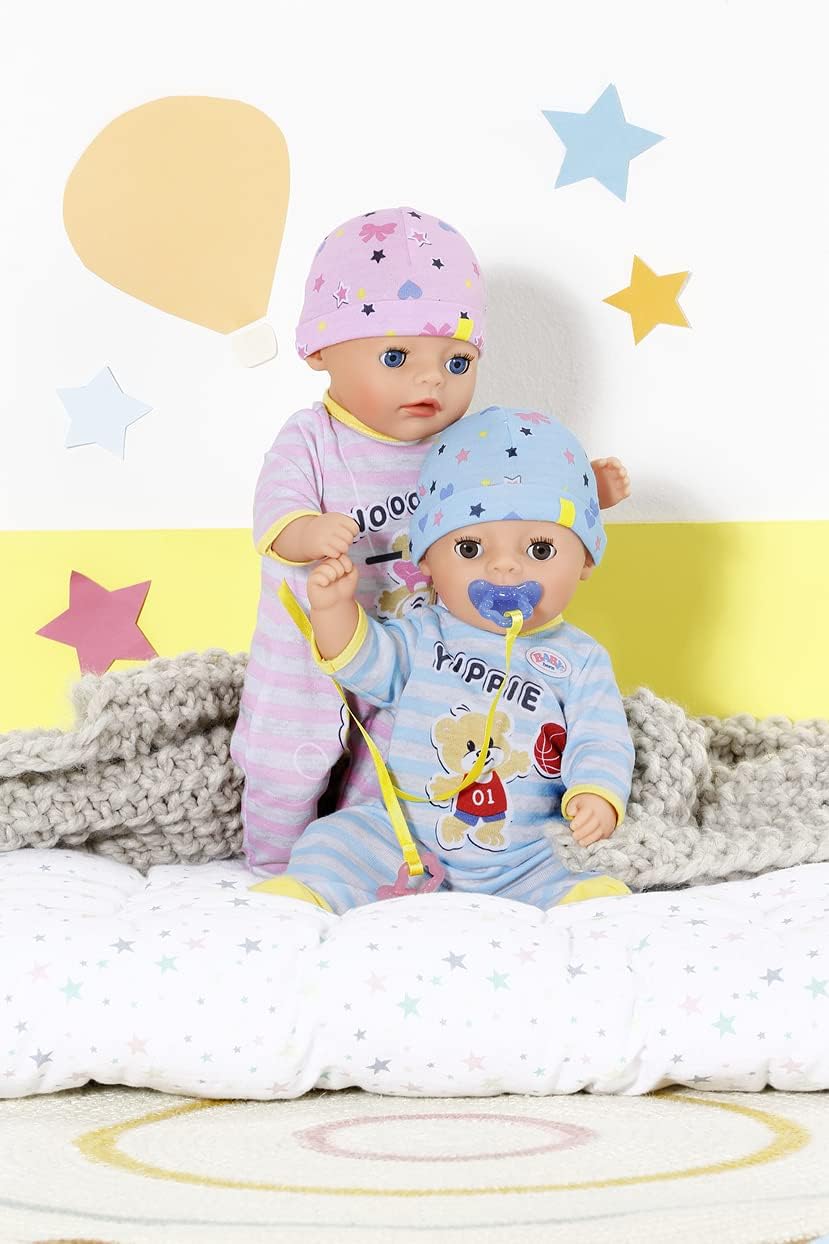 Baby Born doll lying on her back on a pillow, with her eyes closed and a pacifier in her mouth, appearing to be asleep.