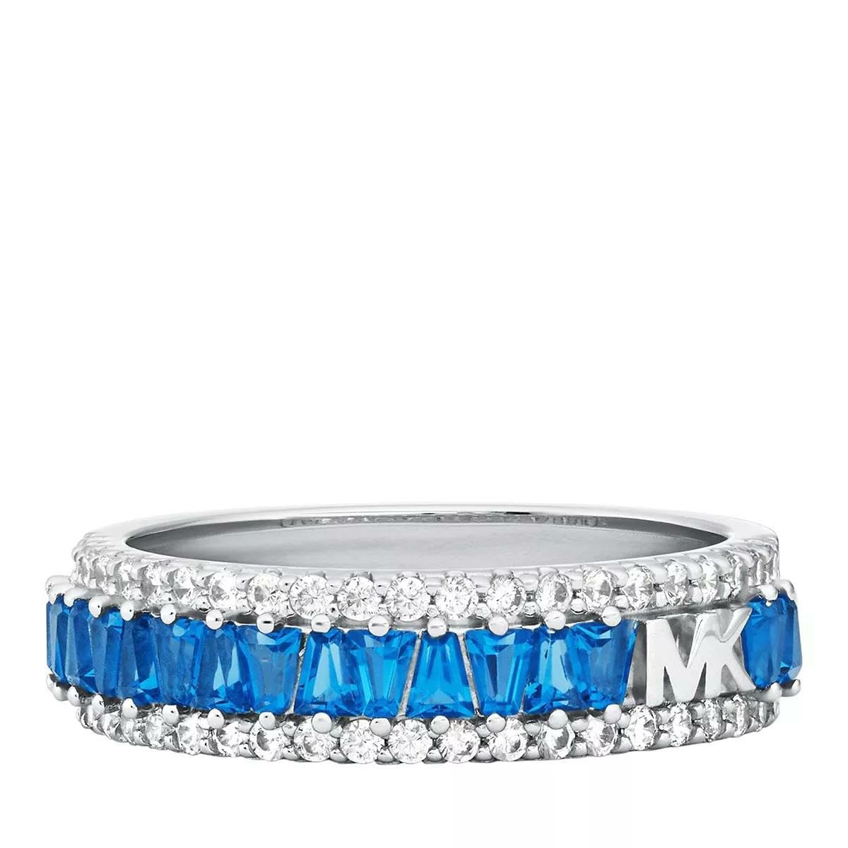 Michael Kors Anillo de hombre Colección Brilliance. Joya fabricada en acero inoxidable dorado con acabado brillante y con perla blanca y cristales azules. Medida del anillo: 15. Acero hipoalergénico