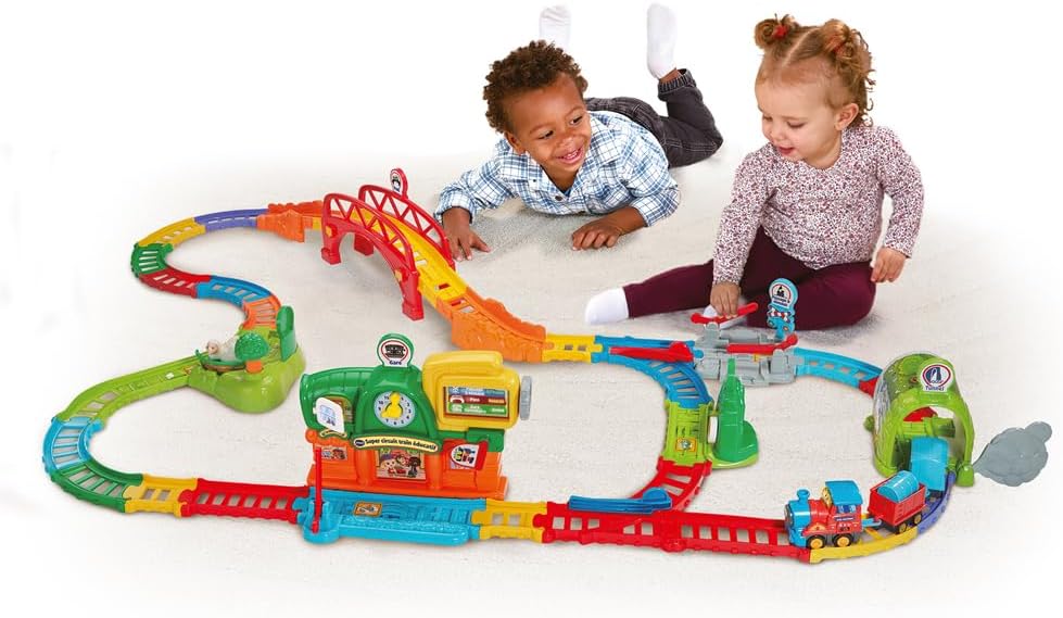 Two children playing with the VTech Tut Tut Bolides Super Circuit Train
