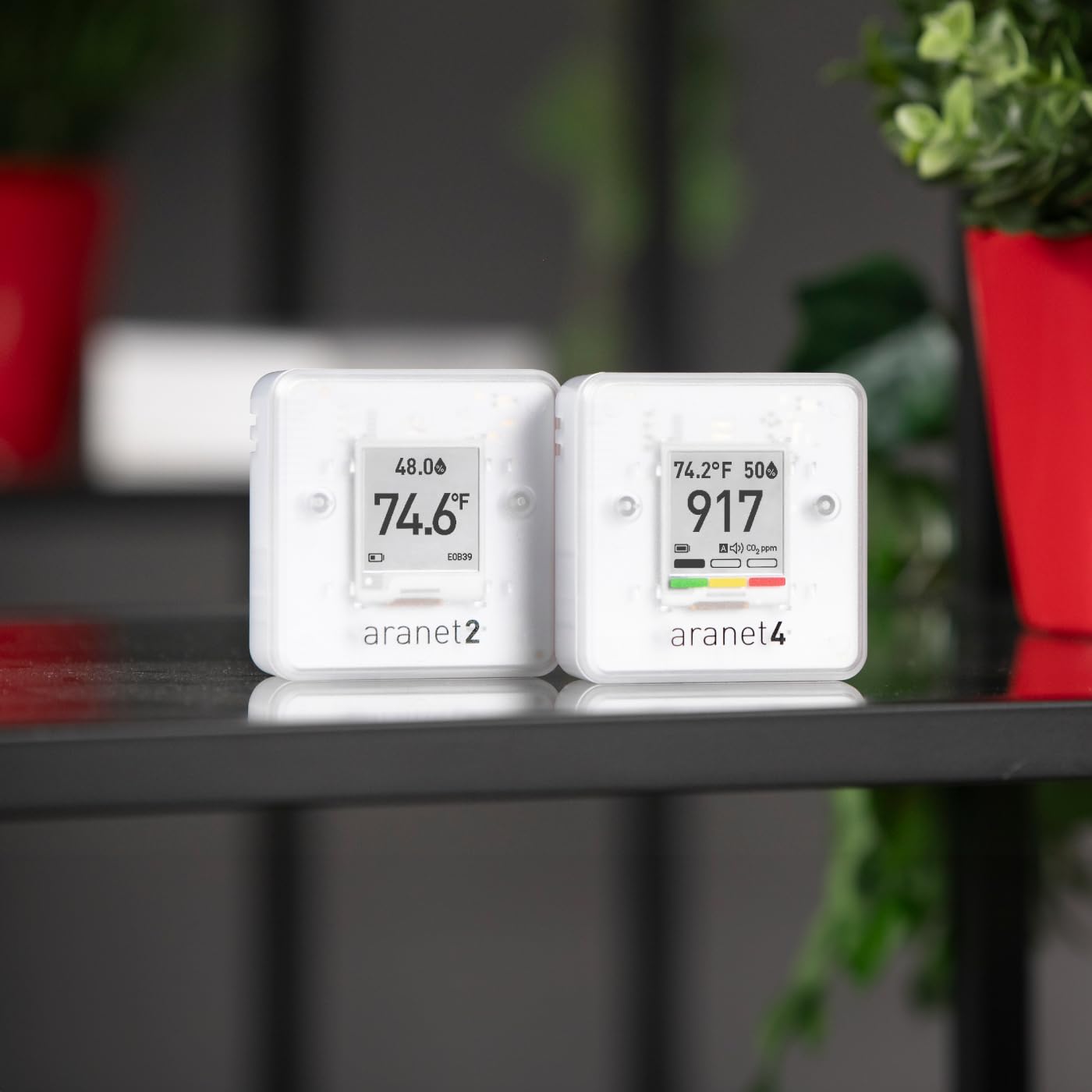 Aranet4 and Aranet2 devices placed on a shelf in an indoor setting.