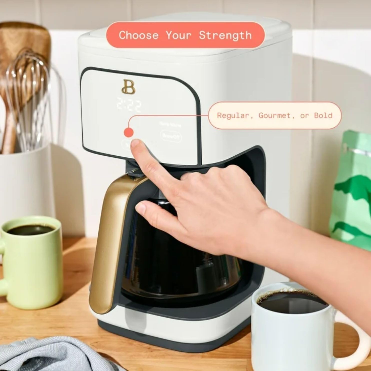 A hand pressing the strength button on the coffee maker, with options for Regular, Gourmet, or Bold brew.
