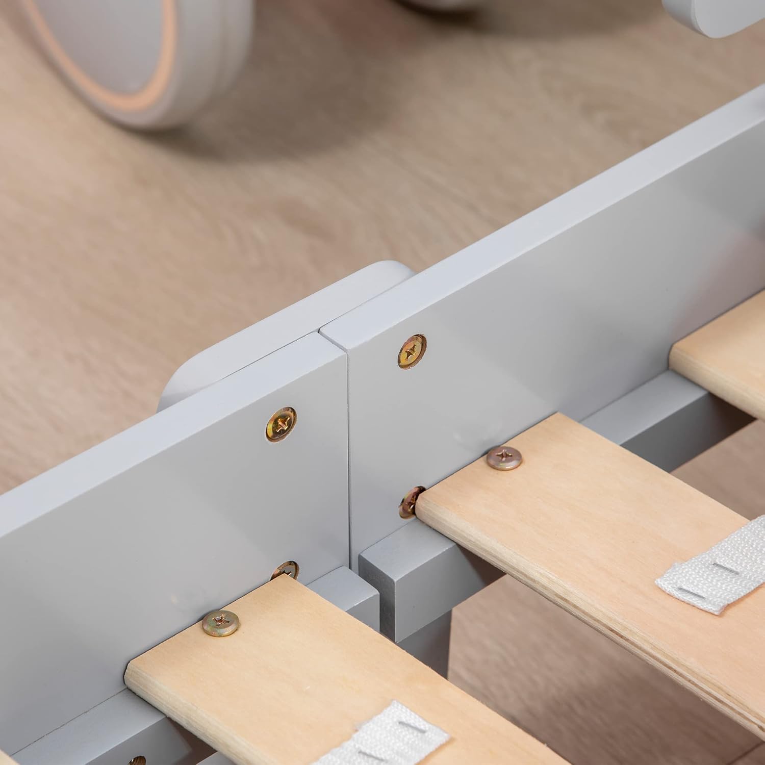 تړل view of the bed's construction, showing how the wooden slats are attached to the frame with screws and fabric straps for stability.