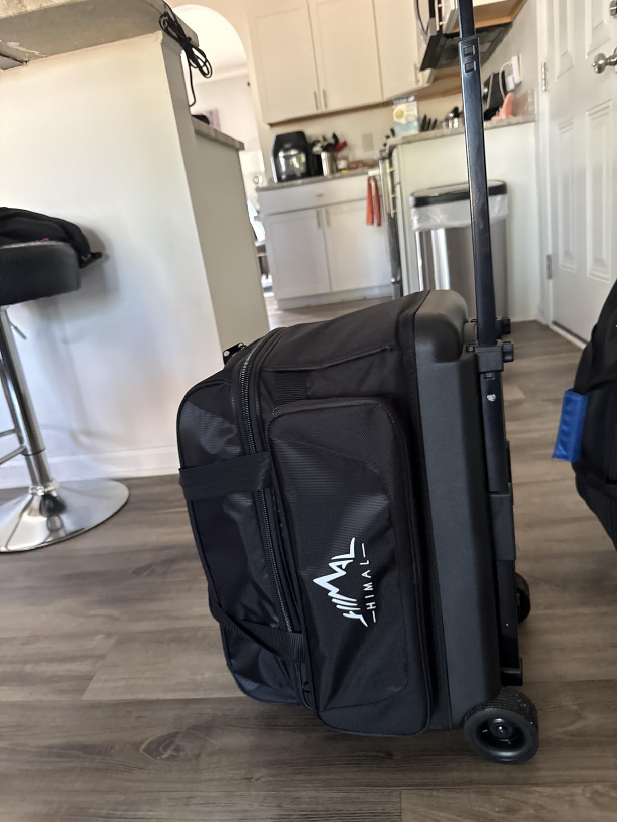 Double roller bowling bag with two ball compartments and an accessory pocket, shown upright on its wheels