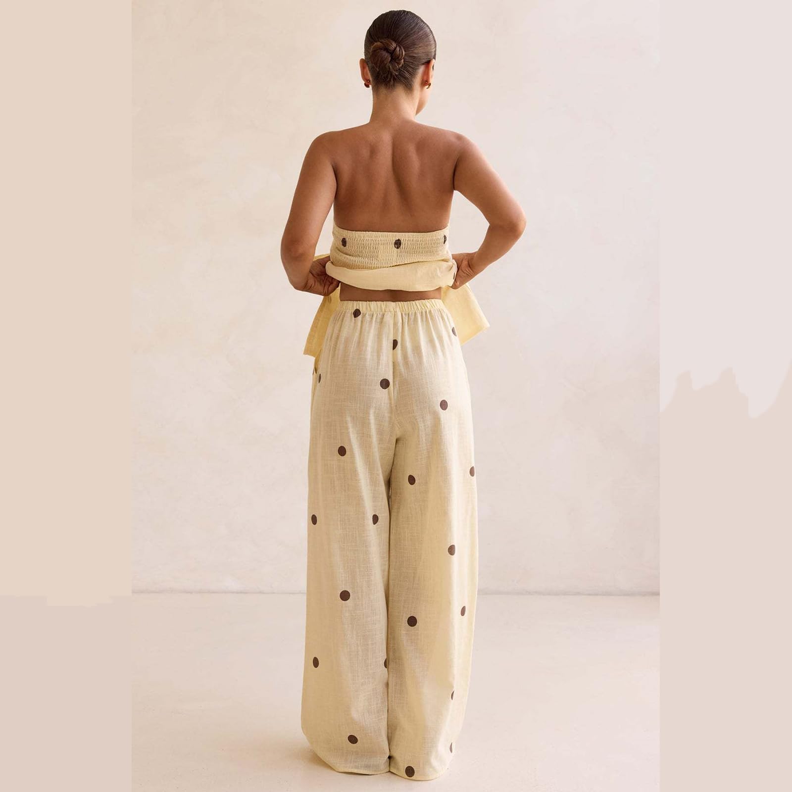 Ensemble deux pièces à pois pour femme : haut bustier sans bretelles et pantalon large taille haute. Collection été 2026.