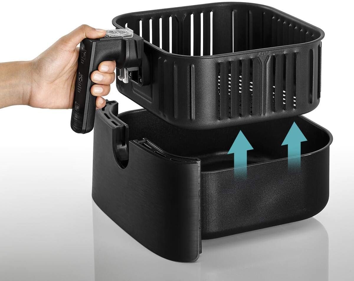 Hand removing the frying basket from the air fryer