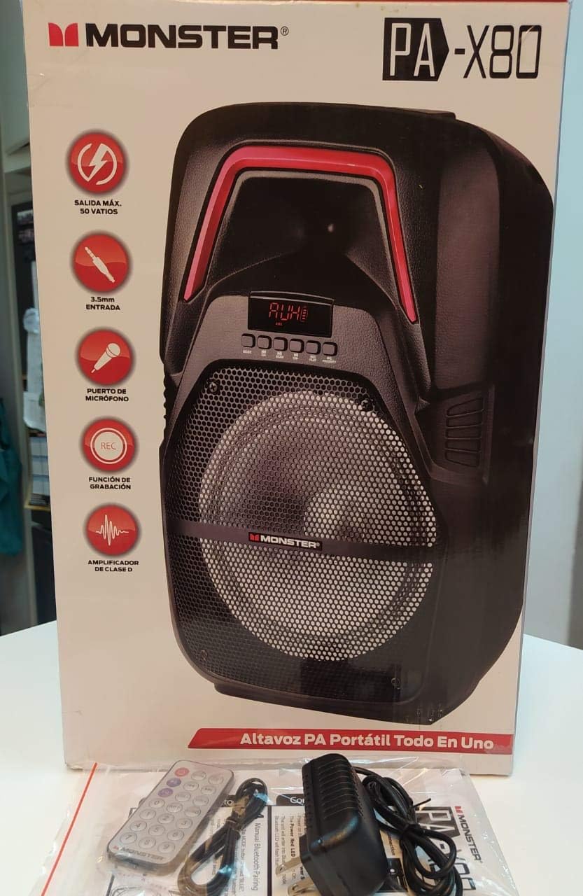 L'altoparlante Monster PA X80 è stato disimballato, esposto con la sua confezione, il telecomando, il microfono e l'adattatore di alimentazione.
