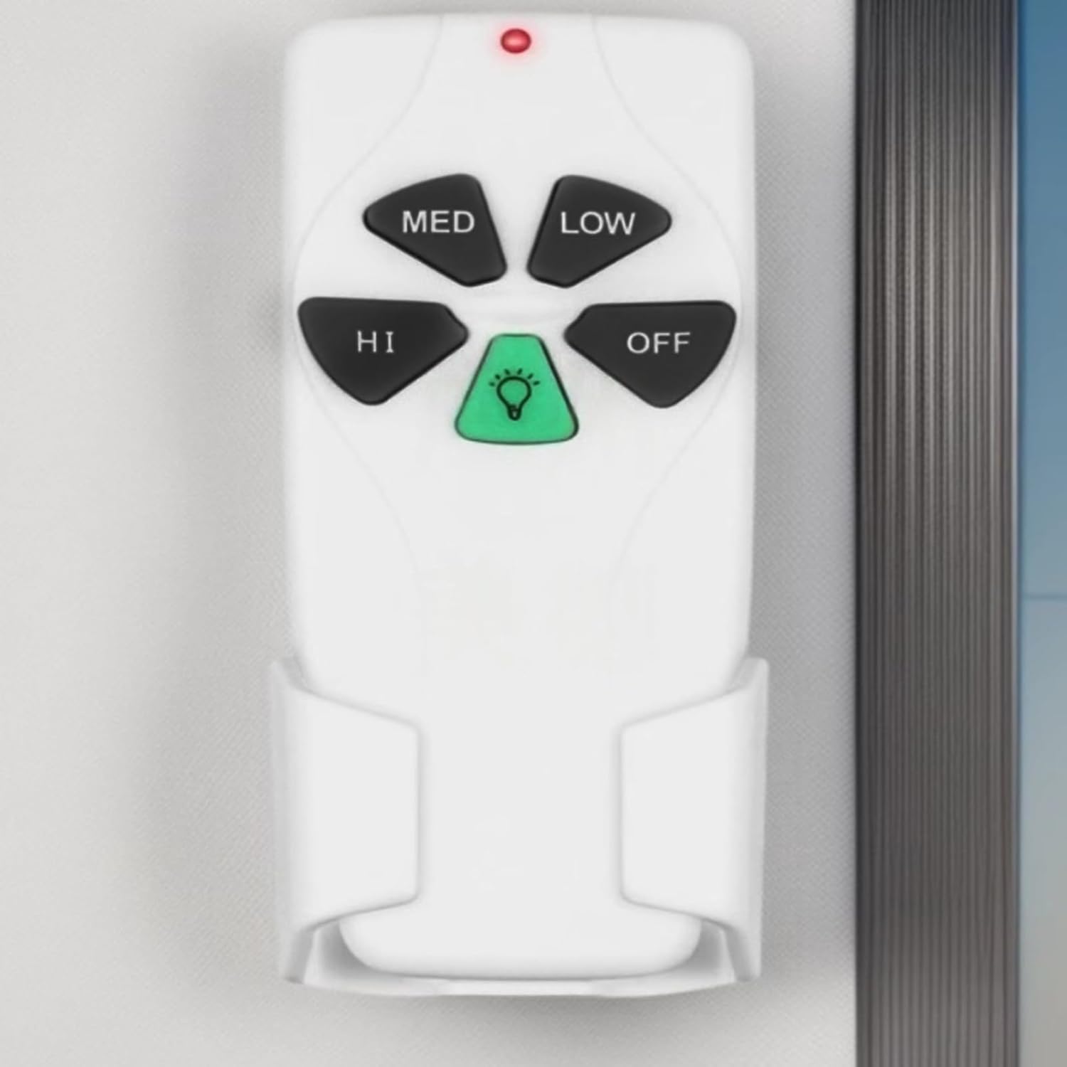 The remote control placed in a wall-mounted holder, providing convenient storage and access.