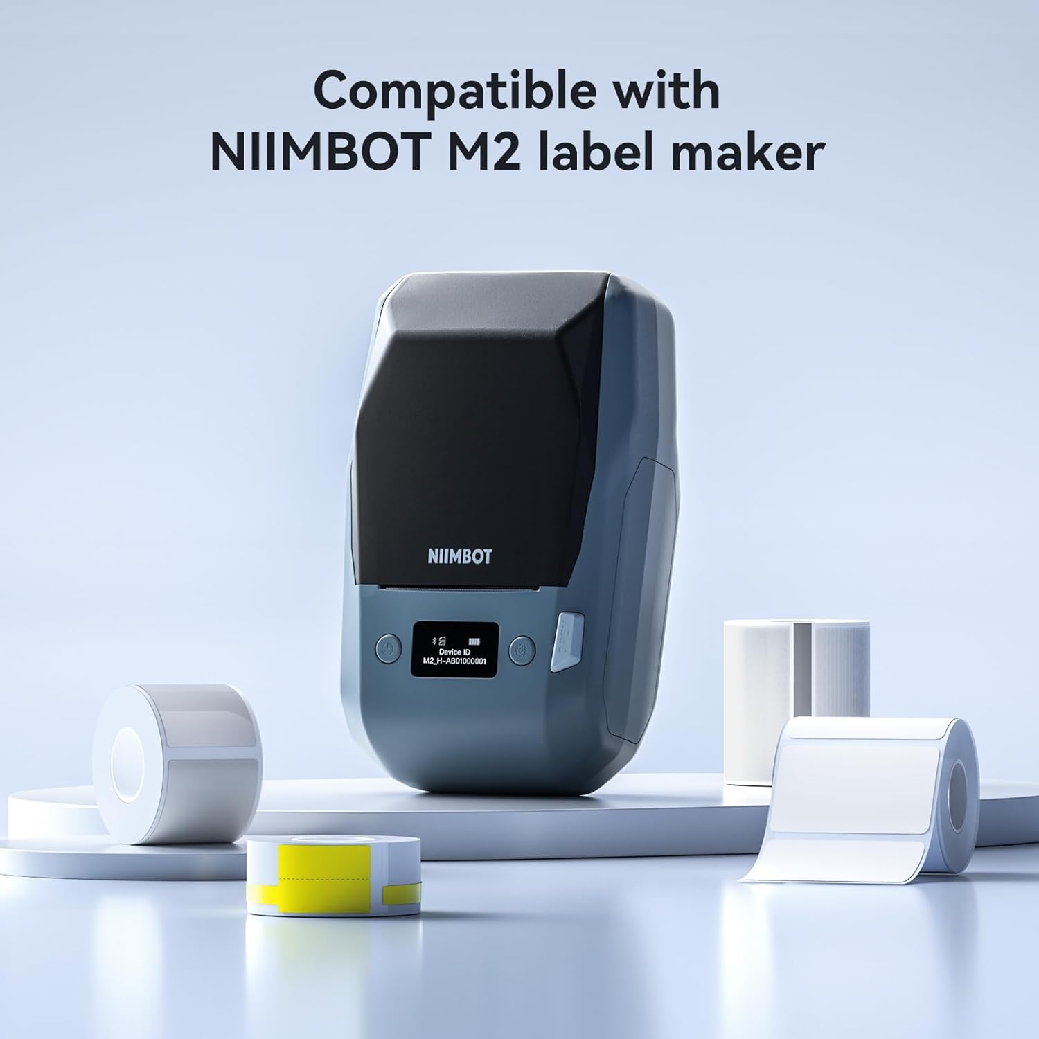 NIIMBOT M2 label maker surrounded by various rolls of labels, indicating compatibility.